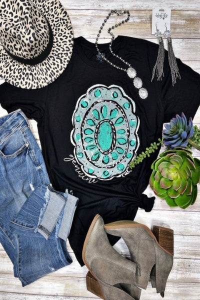 Black t-shirt with teal and white design, leopard print hat, denim shorts, gray ankle boots, and succulents on a wooden surface.