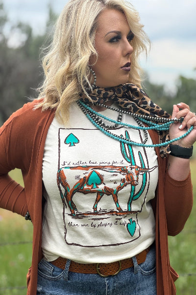 Woman wearing a shirt with a cow graphic and text, standing outdoors.