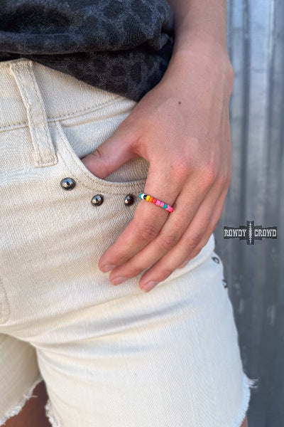 A close-up of a person's hand wearing a colorful beaded ring, styled with off-white denim shorts and a dark patterned top. The brand logo 'BONDO + CROWD' is visible on the right side of the image available at Cowtown Bling N things.