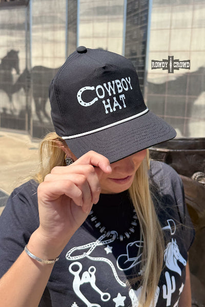 A woman wearing a black baseball cap with white embroidered text reading 'COWBOY HAT' and a white stripe under the brim, photographed outdoors in front of a glass building. The brand name 'RANCH ROYAL' is visible as a watermark/logo in the upper right available at Cowtown Bling N Things.