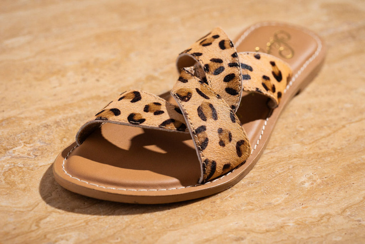 Leopard print sandal on a beige stone surface