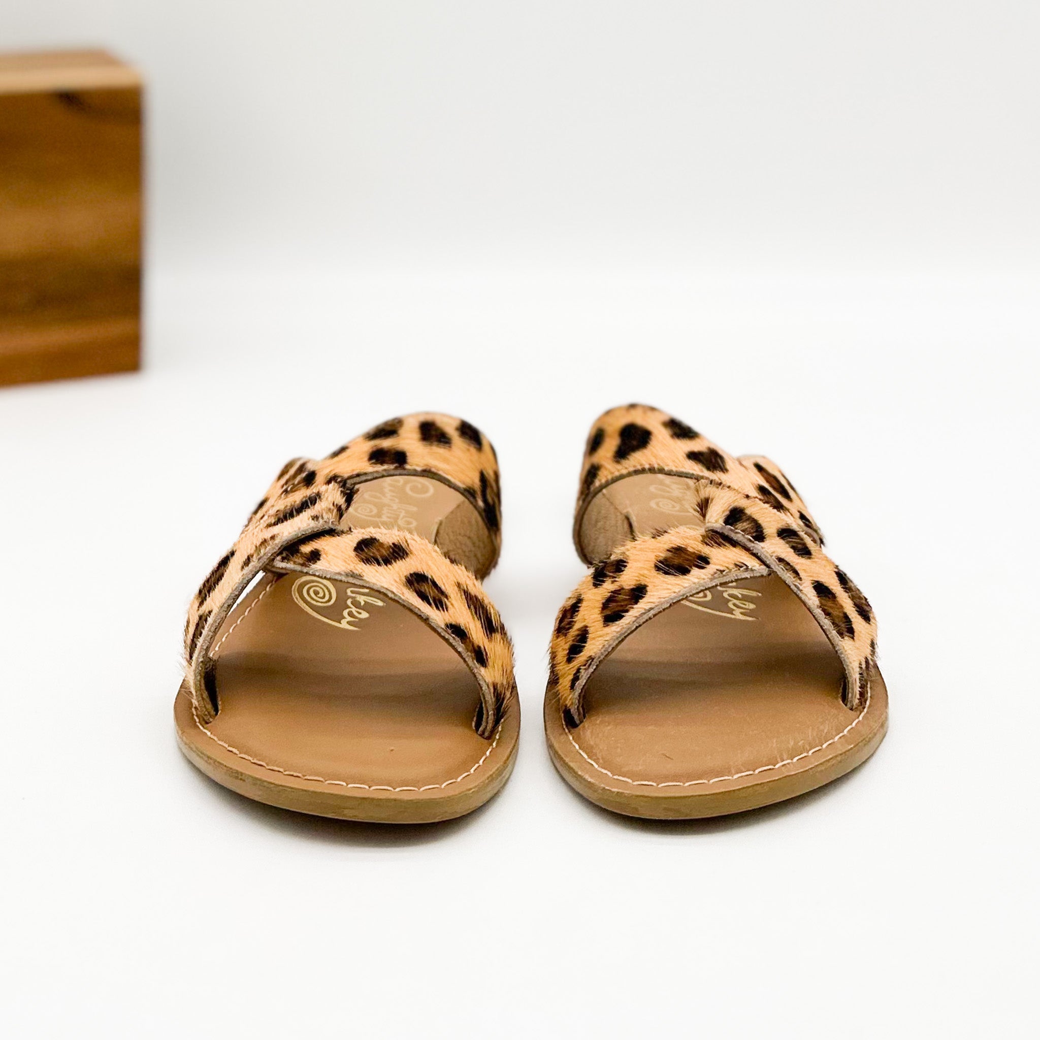 Pair of leopard print sandals on a white background