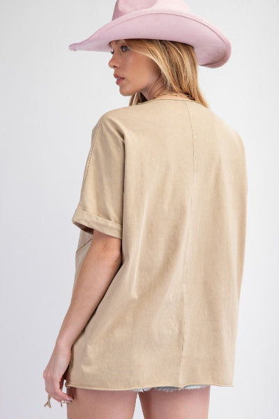 Person wearing a beige oversized shirt and pink hat on a white background