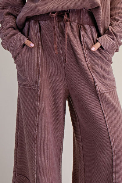 Brown corduroy pants worn by a person on a neutral background