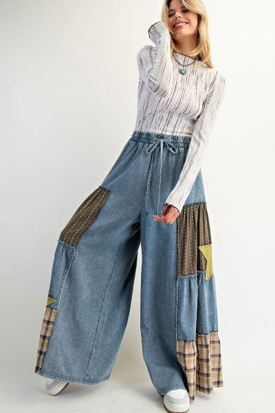 Woman wearing a patchwork denim outfit with a white background