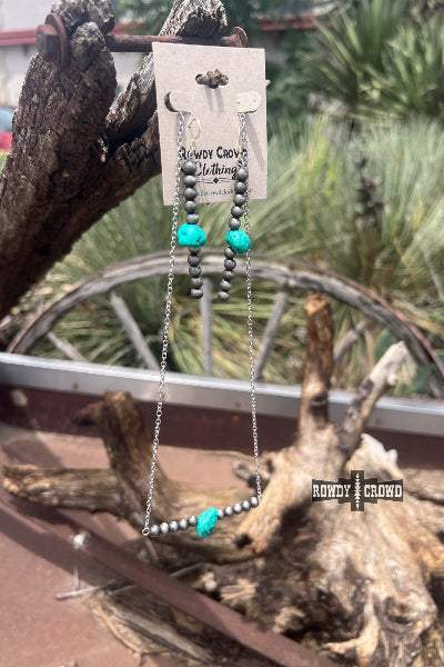 Necklace with turquoise beads on a wooden stand with a blurred natural background