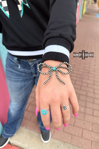 Person wearing multiple rings on a hand with a blurred background