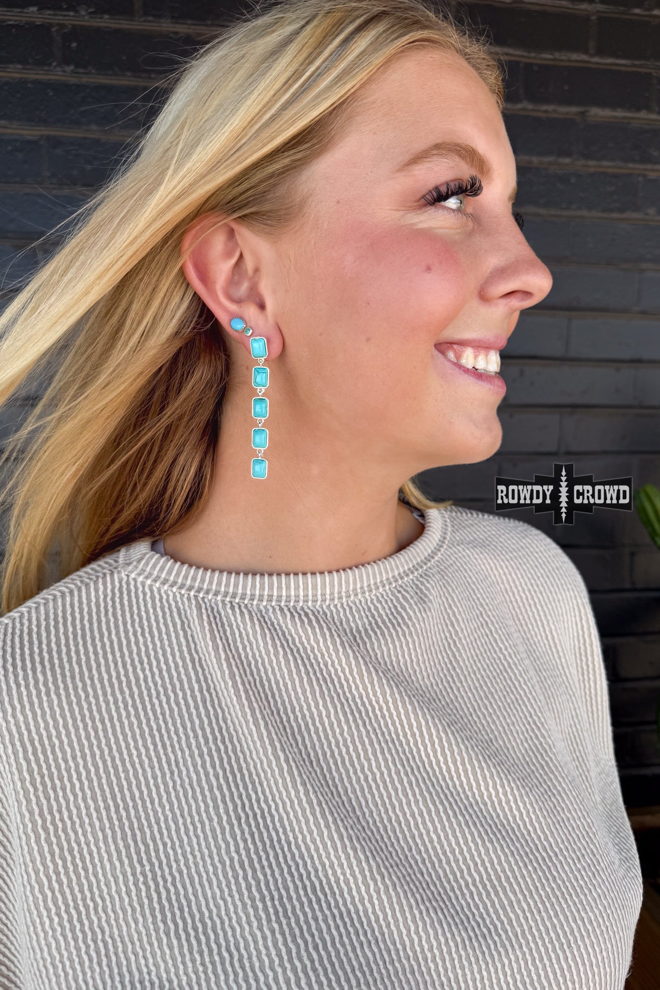 Woman wearing turquoise earrings with a blurred background