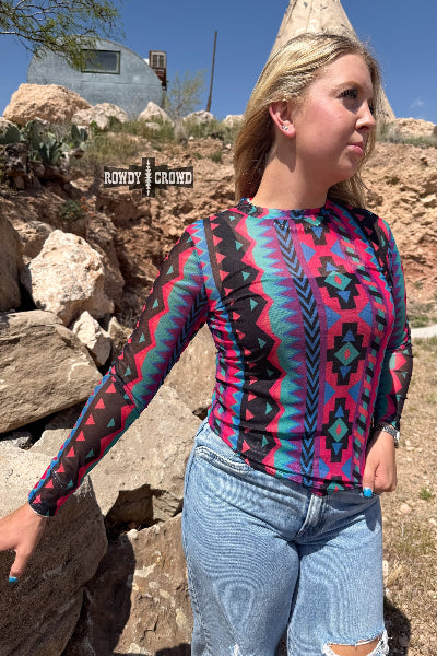 Person wearing a colorful patterned shirt in a desert setting with 'Bundy & Crow' branding.