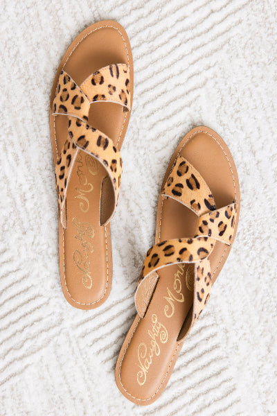 Leopard print sandals with Naughty Monkey branding on a textured white surface