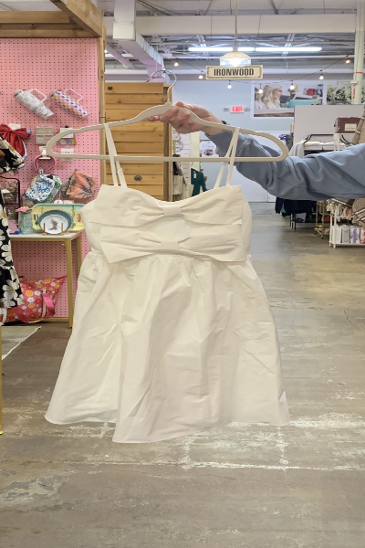 eesome brand white bow dress with spaghetti straps on hanger, model holding