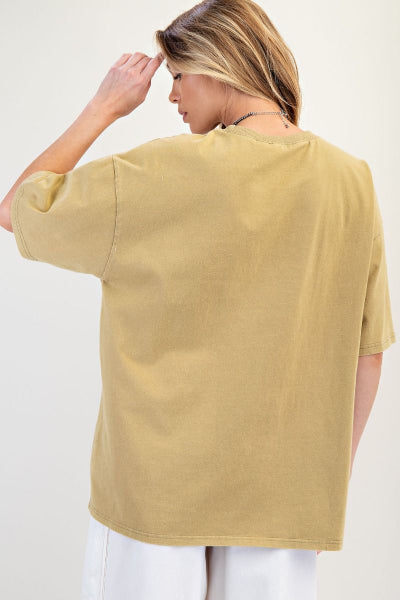 Woman wearing a mustard yellow top against a white background