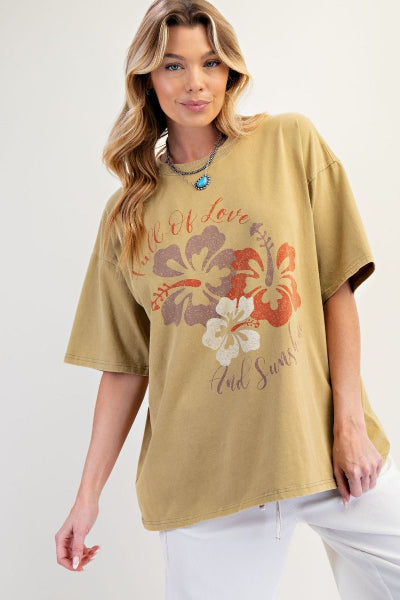 Woman wearing a beige t-shirt with floral design and text on a plain background